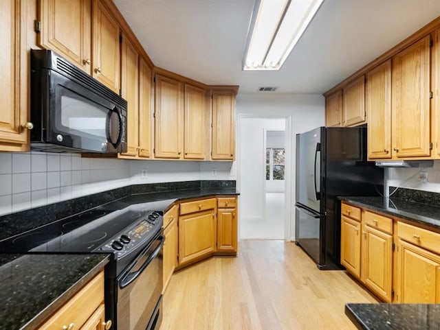 2910 Waverly Place Dr, Dacula, GA 30019 - kitchen with black appliances, light wood-style floors, decorative backsplash, and dark stone counters