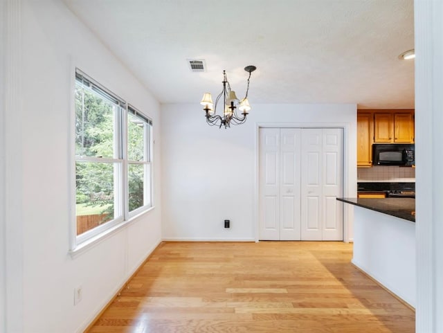 2910 Waverly Place Dr, Dacula, GA 30019 - unfurnished dining area with light wood-style flooring, a chandelier, and baseboards