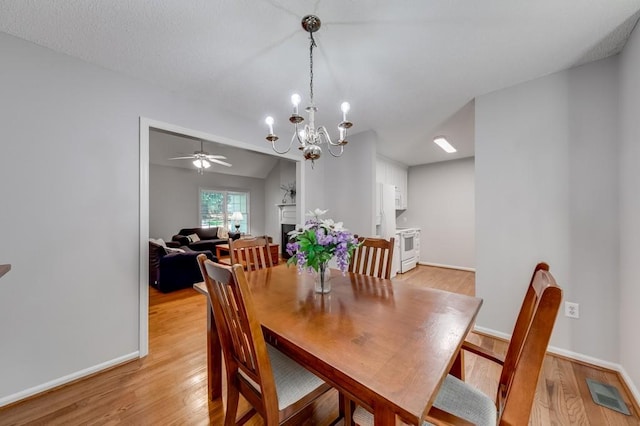 215 Twin Creek Shrs, Athens, GA 30605 - dining room with a chandelier, light wood finished floors, a ceiling fan, and a fireplace
