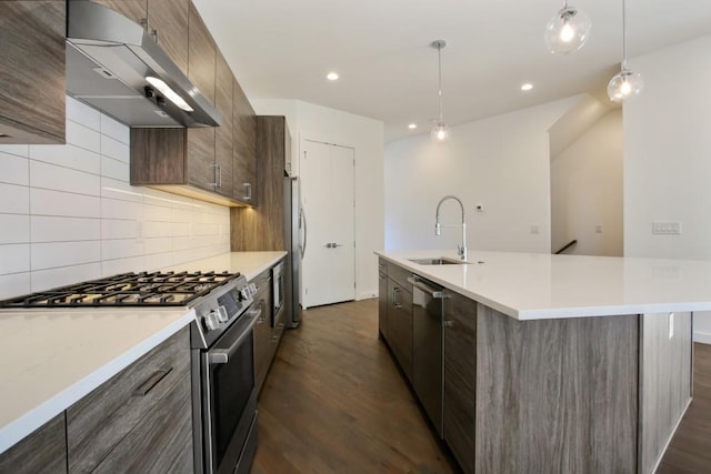 kitchen featuring appliances with stainless steel finishes, dark hardwood / wood-style flooring, sink, pendant lighting, and range hood