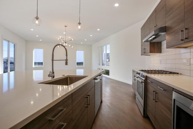 kitchen with a healthy amount of sunlight, sink, appliances with stainless steel finishes, and dark wood-type flooring