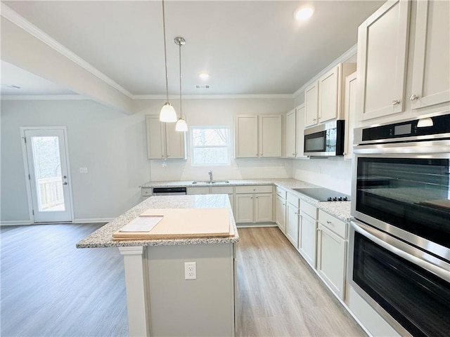 kitchen with light wood finished floors, a center island, stainless steel appliances, and crown molding