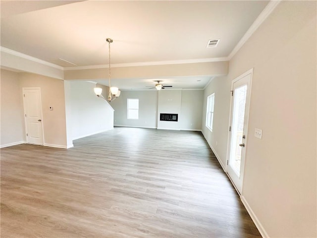 interior space featuring wood finished floors, a glass covered fireplace, and ornamental molding