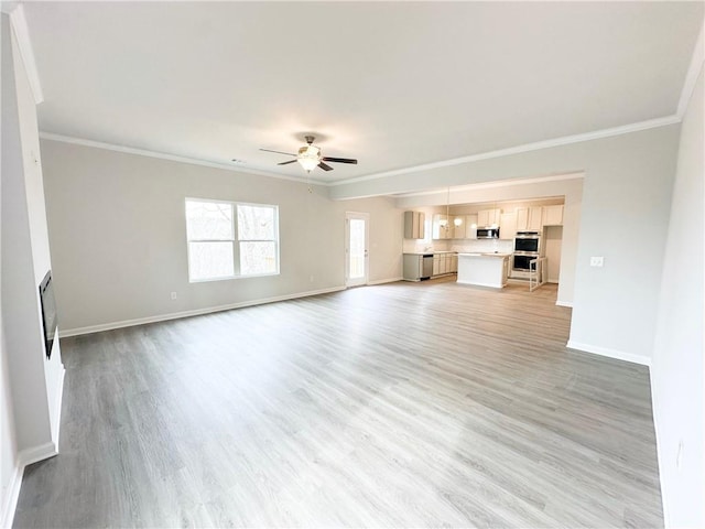 unfurnished living room featuring light wood-type flooring, baseboards, a ceiling fan, and crown molding