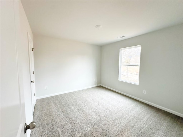 empty room with visible vents, baseboards, and carpet