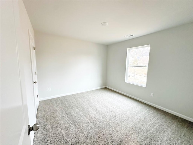 carpeted empty room featuring visible vents and baseboards