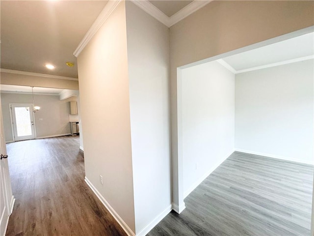 corridor featuring baseboards, wood finished floors, and crown molding