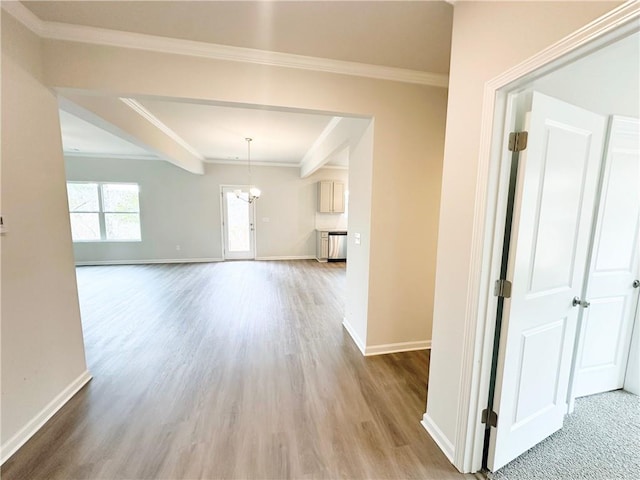 interior space featuring an inviting chandelier, wood finished floors, baseboards, and ornamental molding