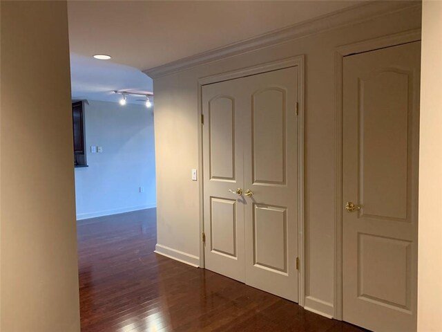 corridor with ornamental molding and dark hardwood / wood-style flooring