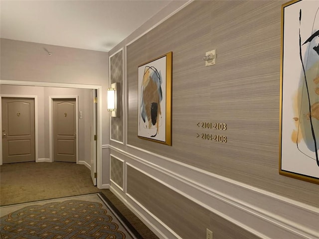 hall with dark colored carpet