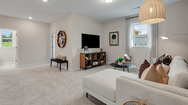 living room featuring baseboards, plenty of natural light, visible vents, and carpet flooring