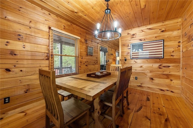 dining room with wood-type flooring, a notable chandelier, wood walls, and wooden ceiling