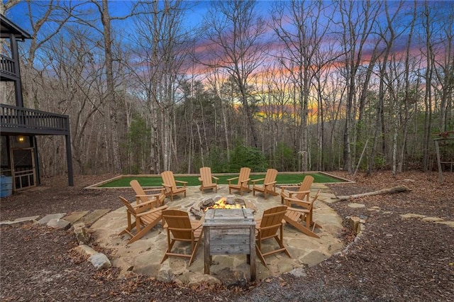 patio terrace at dusk with a fire pit and a deck