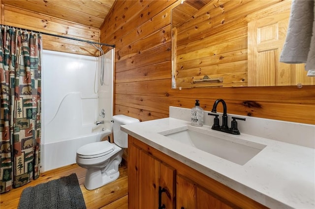 full bathroom with wooden walls, shower / bath combination with curtain, toilet, and vanity