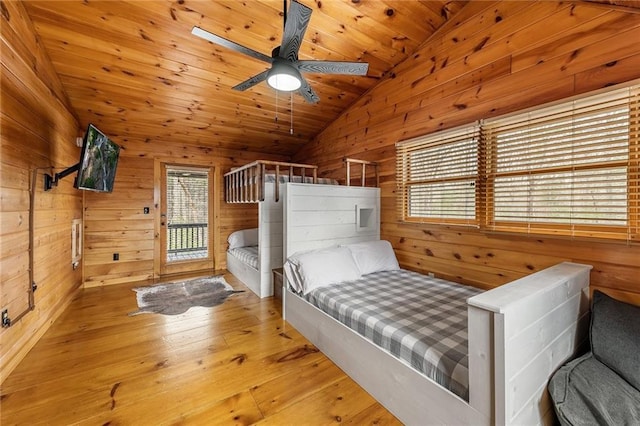 bedroom with access to outside, hardwood / wood-style flooring, wood walls, wooden ceiling, and lofted ceiling