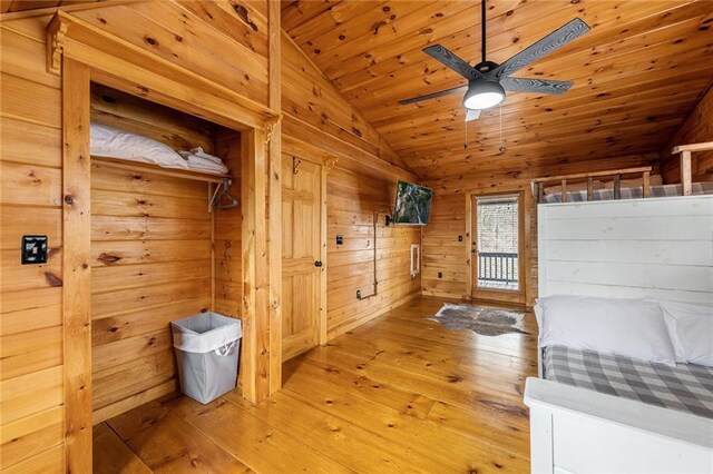 unfurnished bedroom with wood walls, wood ceiling, vaulted ceiling, light wood-style floors, and access to outside