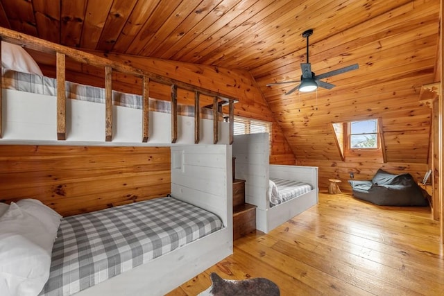 bedroom with lofted ceiling, wooden walls, light hardwood / wood-style floors, and wooden ceiling