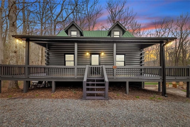 view of front of house with log siding and metal roof