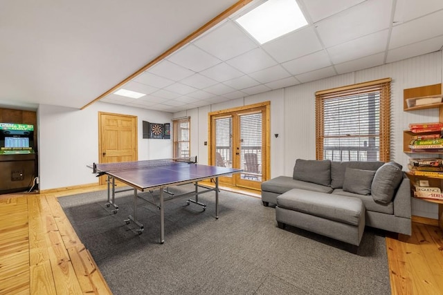 game room with a drop ceiling, hardwood / wood-style flooring, and french doors