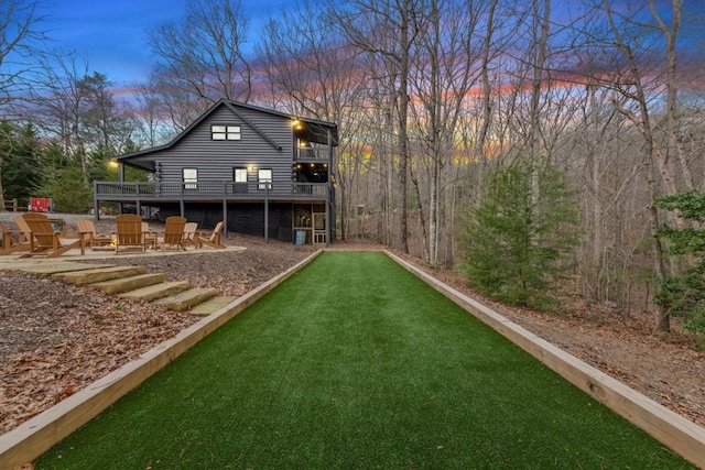 back house at dusk featuring a deck