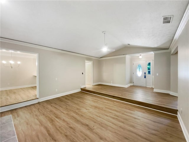 unfurnished living room featuring lofted ceiling, ornamental molding, hardwood / wood-style flooring, and a notable chandelier