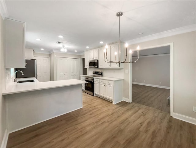 kitchen with stainless steel appliances, white cabinets, sink, and kitchen peninsula