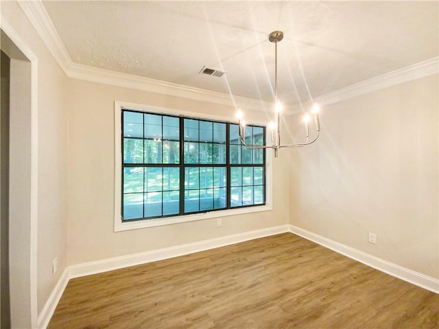 unfurnished dining area with an inviting chandelier, crown molding, and wood-type flooring