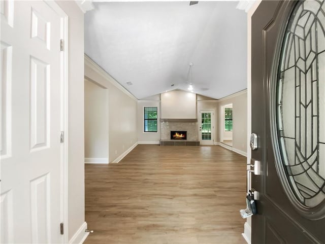 entrance foyer with lofted ceiling, light hardwood / wood-style floors, and crown molding