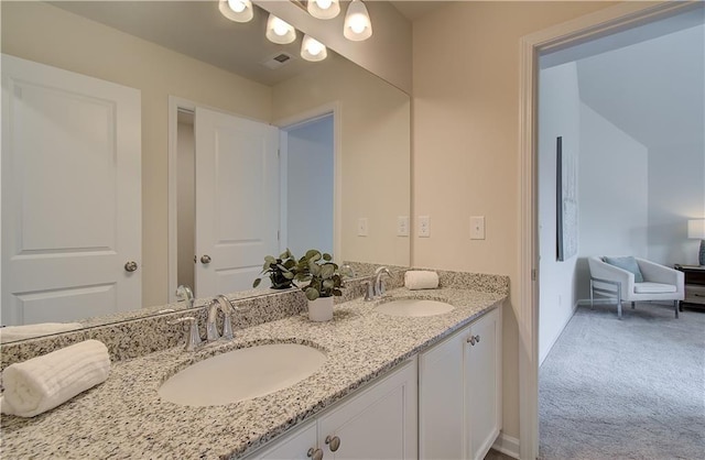 bathroom featuring double vanity, baseboards, and a sink