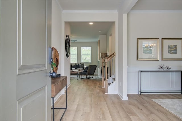 entrance foyer featuring light wood-type flooring, crown molding, and stairway