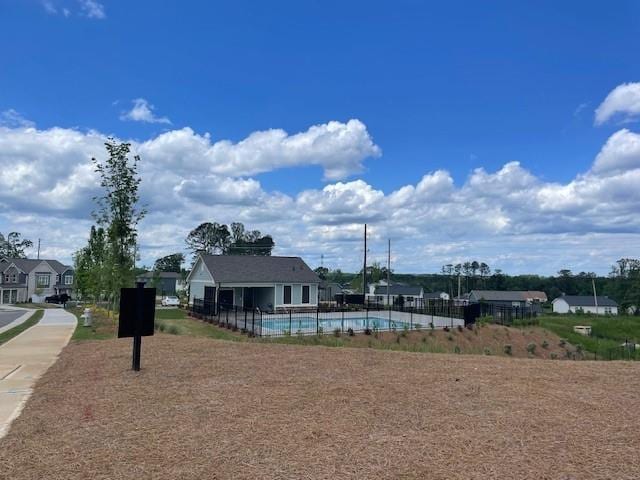 view of home's community with fence and a pool
