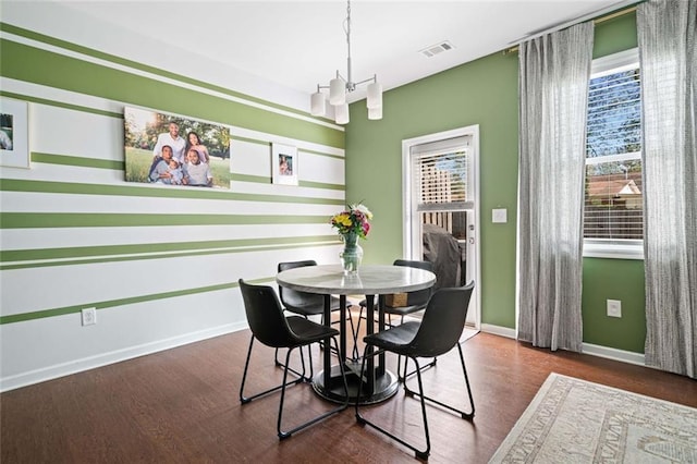 dining area with baseboards, wood finished floors, a chandelier, and visible vents