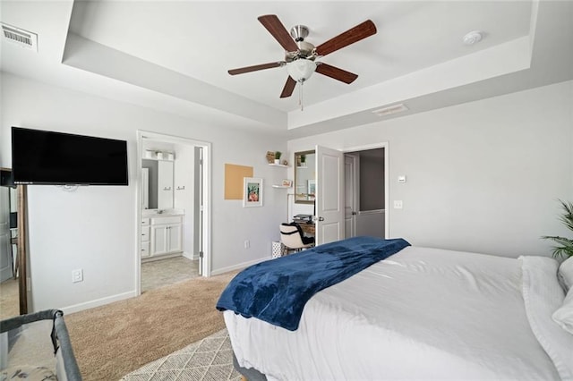 bedroom with ceiling fan, light carpet, baseboards, a tray ceiling, and visible vents
