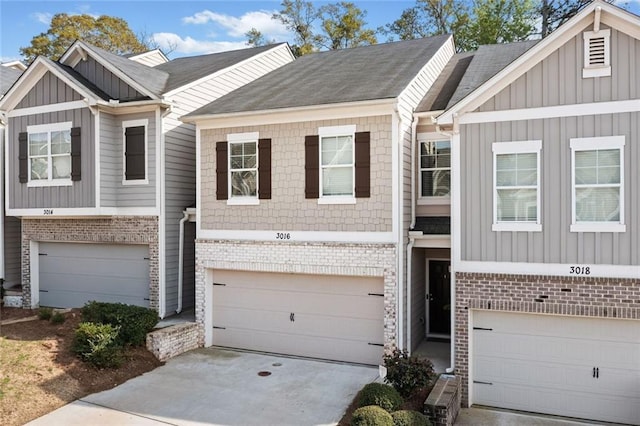 townhome / multi-family property with board and batten siding, a garage, brick siding, concrete driveway, and a shingled roof