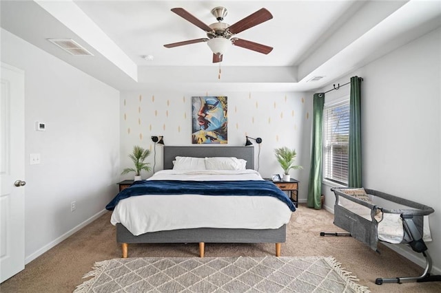 bedroom with visible vents, a raised ceiling, carpet, and baseboards
