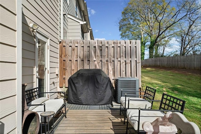 deck featuring fence, central AC unit, a lawn, and area for grilling