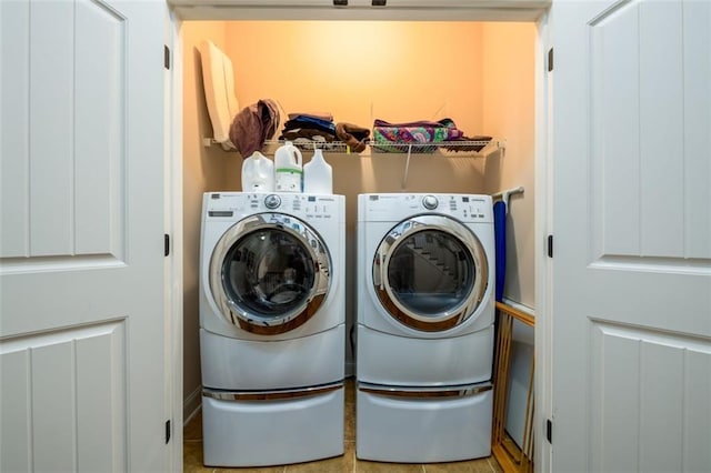 clothes washing area featuring laundry area and washer and clothes dryer