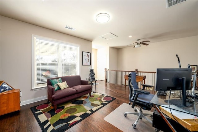 office area with baseboards, visible vents, dark wood finished floors, and a ceiling fan