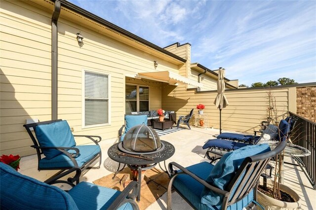 view of patio with an outdoor fire pit and fence