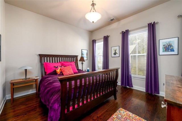 bedroom with dark wood finished floors, visible vents, and baseboards