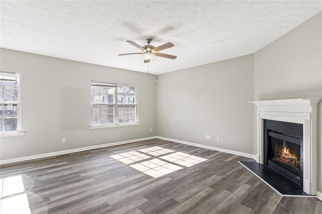 unfurnished living room featuring a textured ceiling, dark hardwood / wood-style floors, and ceiling fan