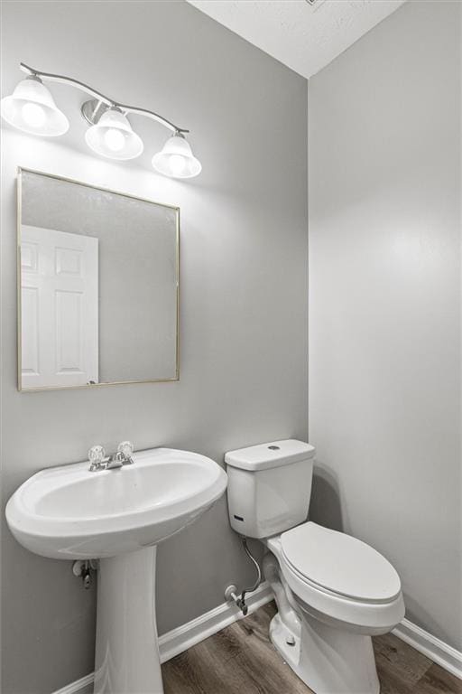 bathroom with sink, hardwood / wood-style floors, and toilet