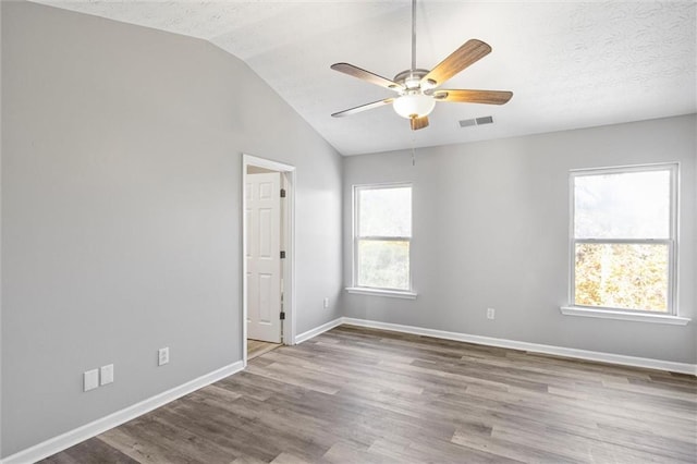 spare room featuring ceiling fan, wood-type flooring, a textured ceiling, and vaulted ceiling