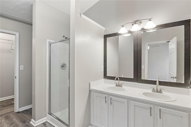 bathroom featuring ceiling fan, a shower with door, vanity, and hardwood / wood-style flooring