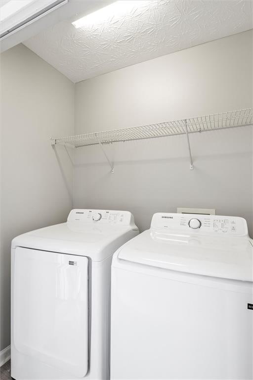 laundry room with a textured ceiling and independent washer and dryer