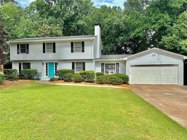 colonial inspired home with brick siding, a garage, a front yard, a chimney, and concrete driveway
