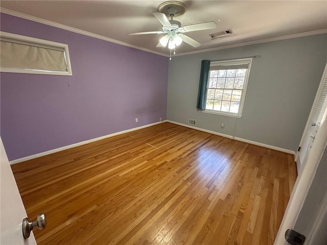unfurnished bedroom featuring visible vents, ornamental molding, and wood finished floors