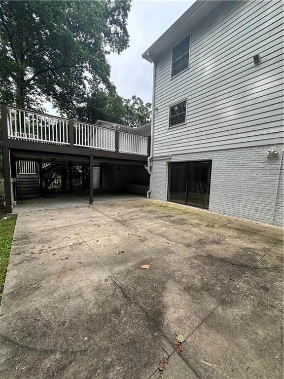 6542 Cherry Tree Ln, Atlanta, GA 30328 - view of home's exterior with a wooden deck, driveway, a carport, and brick siding