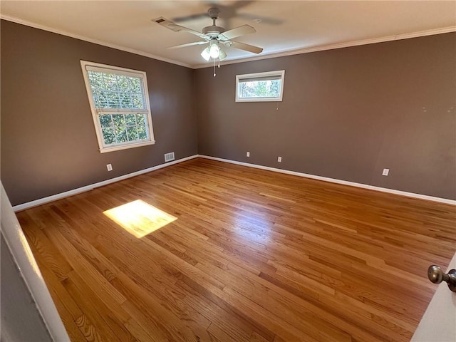 empty room featuring baseboards, ceiling fan, visible vents, and wood finished floors
