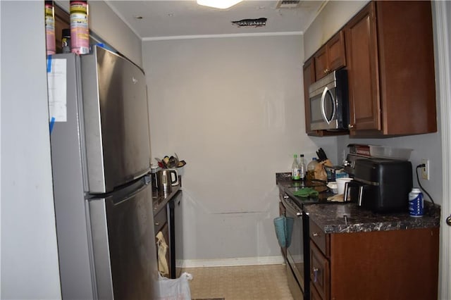 kitchen with dark stone counters and appliances with stainless steel finishes